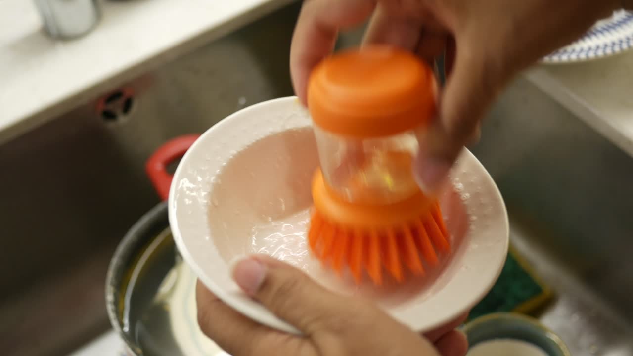 Lavando platos en el fregadero de la cocina