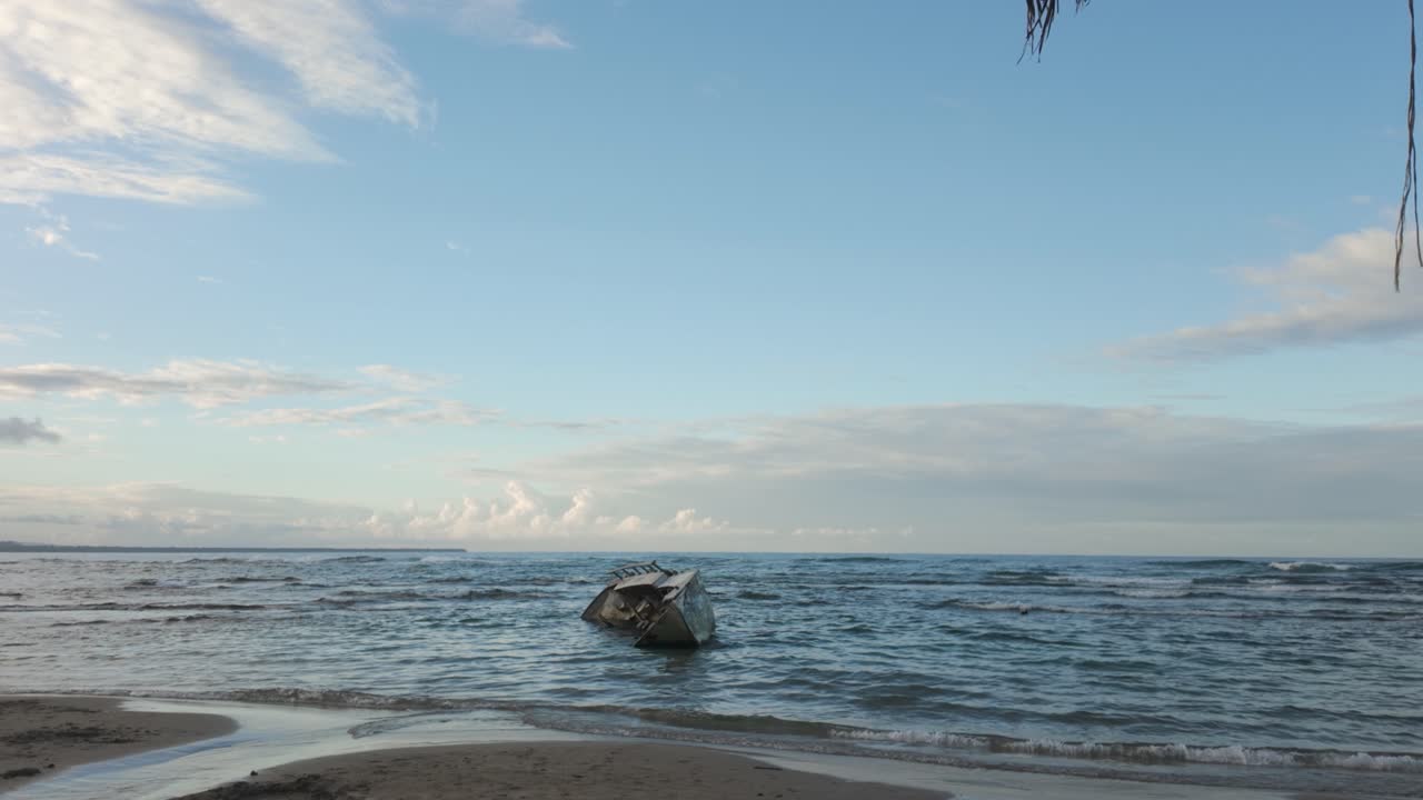 Pristine coastline in Puerto Viejo, Costa Rica, with turquoise waters, palm trees, scenic tropical views and shipwreck in shallow water