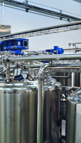 contemporary milk making factory indoors. huge bowls for mixing milk and water. special equipment for preparing cheese. vertical video
