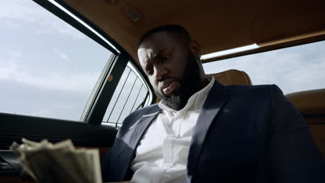 closeup businessman counting dollars at car. man sitting with money at car