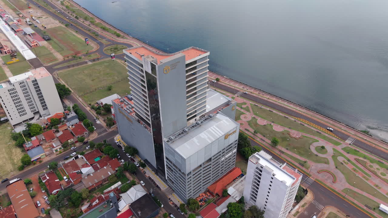 Aerial drone fly Shopping costanera, building in Encarnacion Paraguay next to waterfront vehicle traffic next to the River
