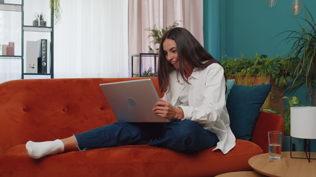 mujer joven muy feliz trabajando en una computadora portátil celebra el éxito gana dinero en la lotería consigue buenas noticias en línea