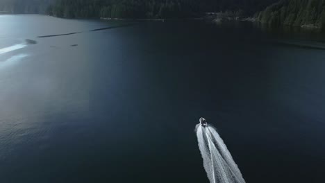 an aerial view as a boat gracefully glides through the waters of princess louisa inlet, bc, canada, within its majestic fjord, exemplifying the concept of serene exploration amidst natural splendor