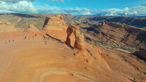 aerial view of delicate arch with tourists in arches national park, utah, usa - drone shot