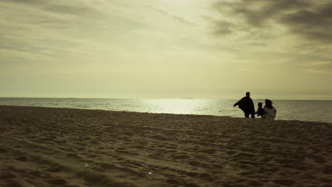 la familia camina juntos por la playa por la mañana. la gente disfruta del amanecer temprano en la costa.