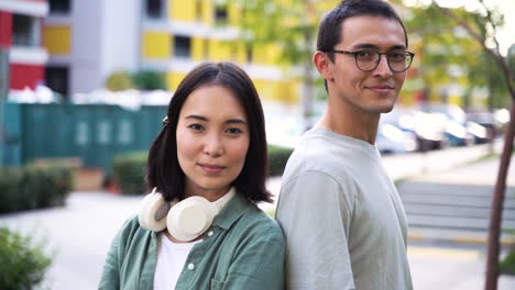 outdoor portrait of two japanese friends smiling and looking at camera in the street