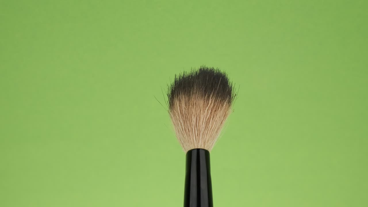 Rotation of the brush for make-up on a green background.