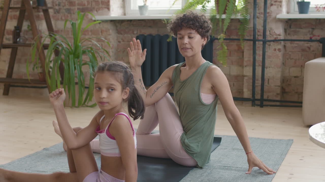madre e hija haciendo yoga en casa