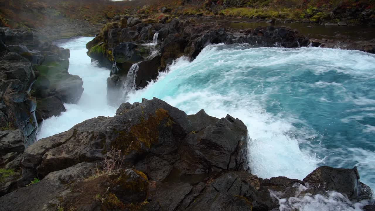 toma en cámara lenta de cascada natural salpicando entre rocas en islandia