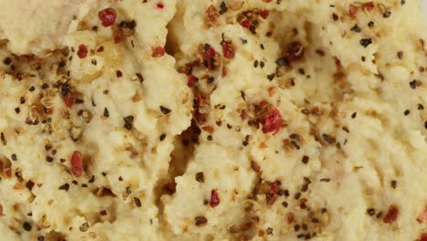 israeli cuisine. hummus texture decorated with spices close-up. national food, middle eastern culture. vegan chickpea puree snack. appetizer made from mashed chickpeas