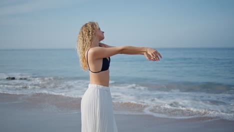 gentle dancer moving body sensually on summer beach. beautiful woman dancing