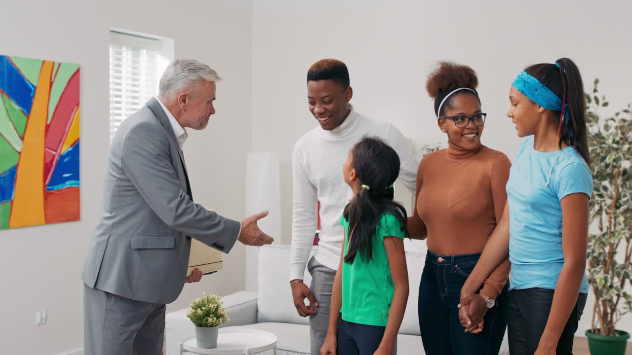 The family decides to rent an apartment, they meet with an experienced real estate agent, a man with gray hair gives the couple information and shakes the guy's hand in congratulations