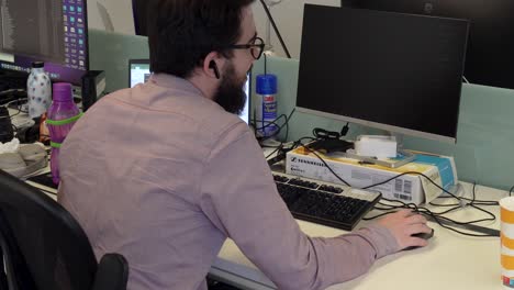 en la oficina, un hombre positivo multitarea, trabajando diligentemente en su computadora portátil mientras participa en una reunión productiva, mostrando su enfoque eficiente y centrado