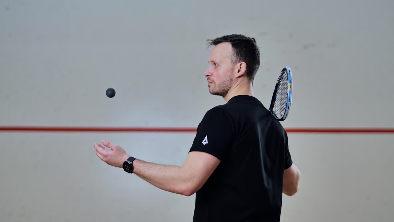 Precision toss and catch by focused player in silent squash court atmosphere
