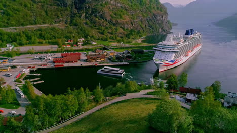 beautiful drone shot over the town of aurlandsfjord in flam, norway on a beautiful spring day with the view of a white cruise ship docked