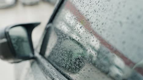 driver side mirror covered with rain droplets while pouring rain