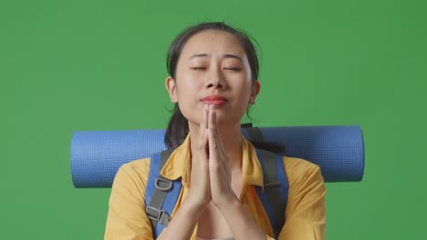 woman praying with backpack