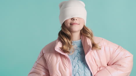 teenage caucasian girl with winter clothes making faces in front of the camera.