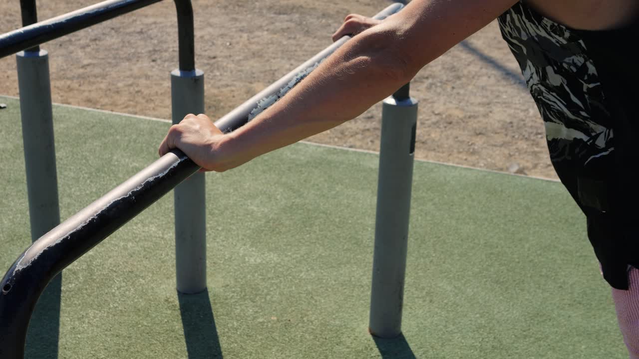 Man performing push-ups on parallel bars outdoors
