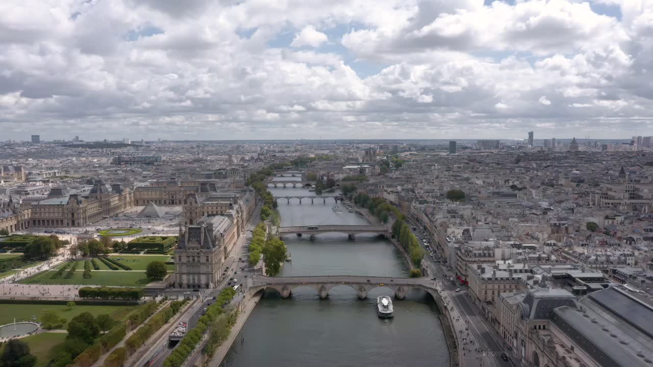 Stunning aerial flying over the Seine River showcasing the Louvre, Tuileries Garden, and Musee d'Orsay surrounded by the historic Parisian skyline