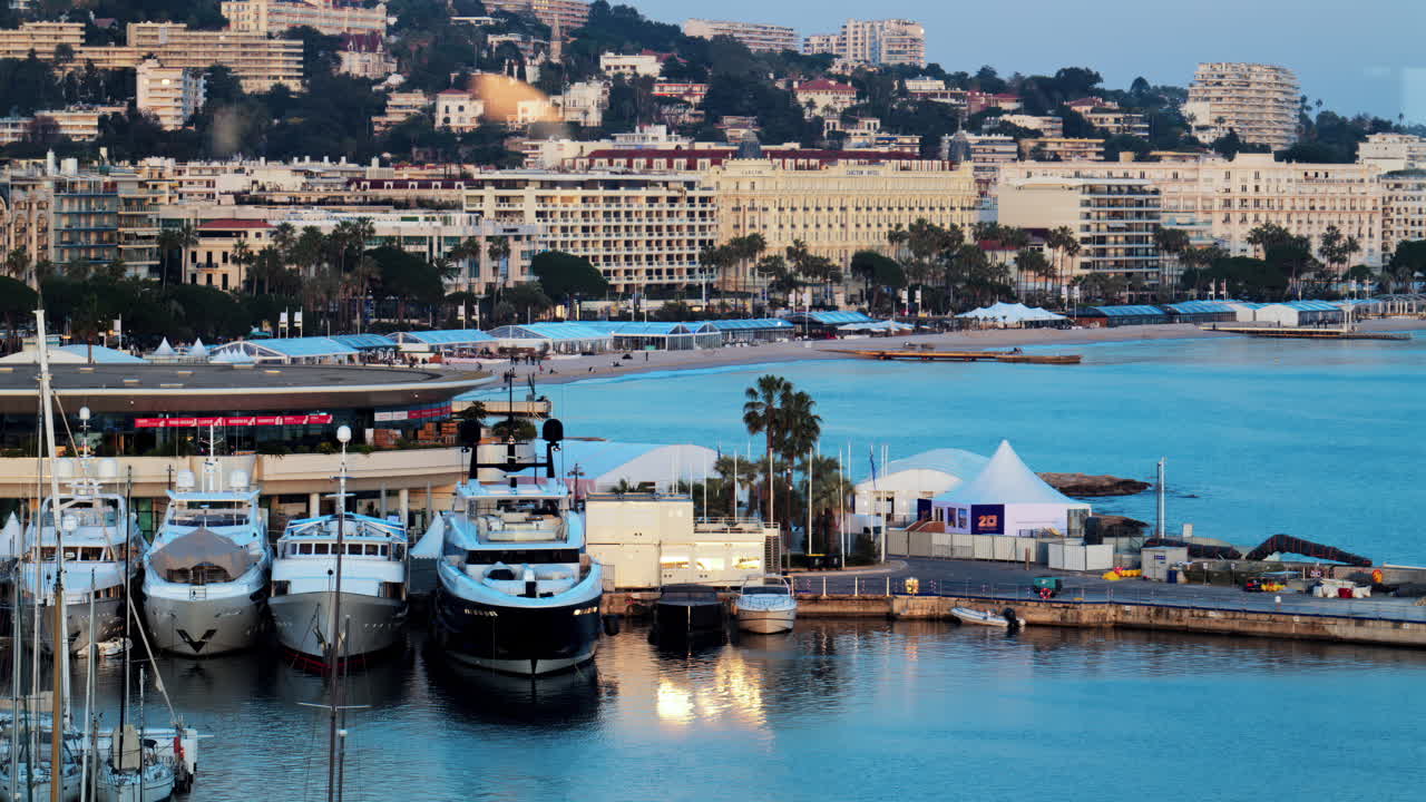 Cannes, France - March 15, 2025: View of multiple boats docked in the Cannes Marina with the buildings of the city on the background at sunset