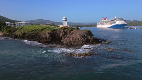 Wunderschöner-Panoramablick-Auf-Die-Felsige-Küste-Mit-Pavillon-Und-Riesigem-Kreuzfahrtschiff-Im-Hintergrund---Sonniger-Tag-Mit-Blauem-Himmel-Auf-Der-Insel-Der-Dominikanischen-Republik---Weitwinkelaufnahme-Aus-Der-Luft