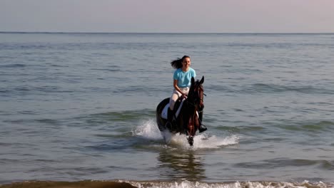 woman horseback riding in the ocean