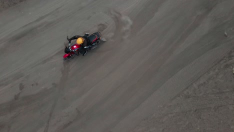 Luftaufnahmen-Eines-Motorradfahrers,-Der-Auf-Einer-Unbefestigten-Straße-Viel-Staub-Aufwirbelt,-Um-Umzukehren