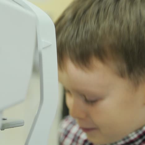 little boy checks eyesight. ophthalmologist measuring intraocular pressure of patient in clinic