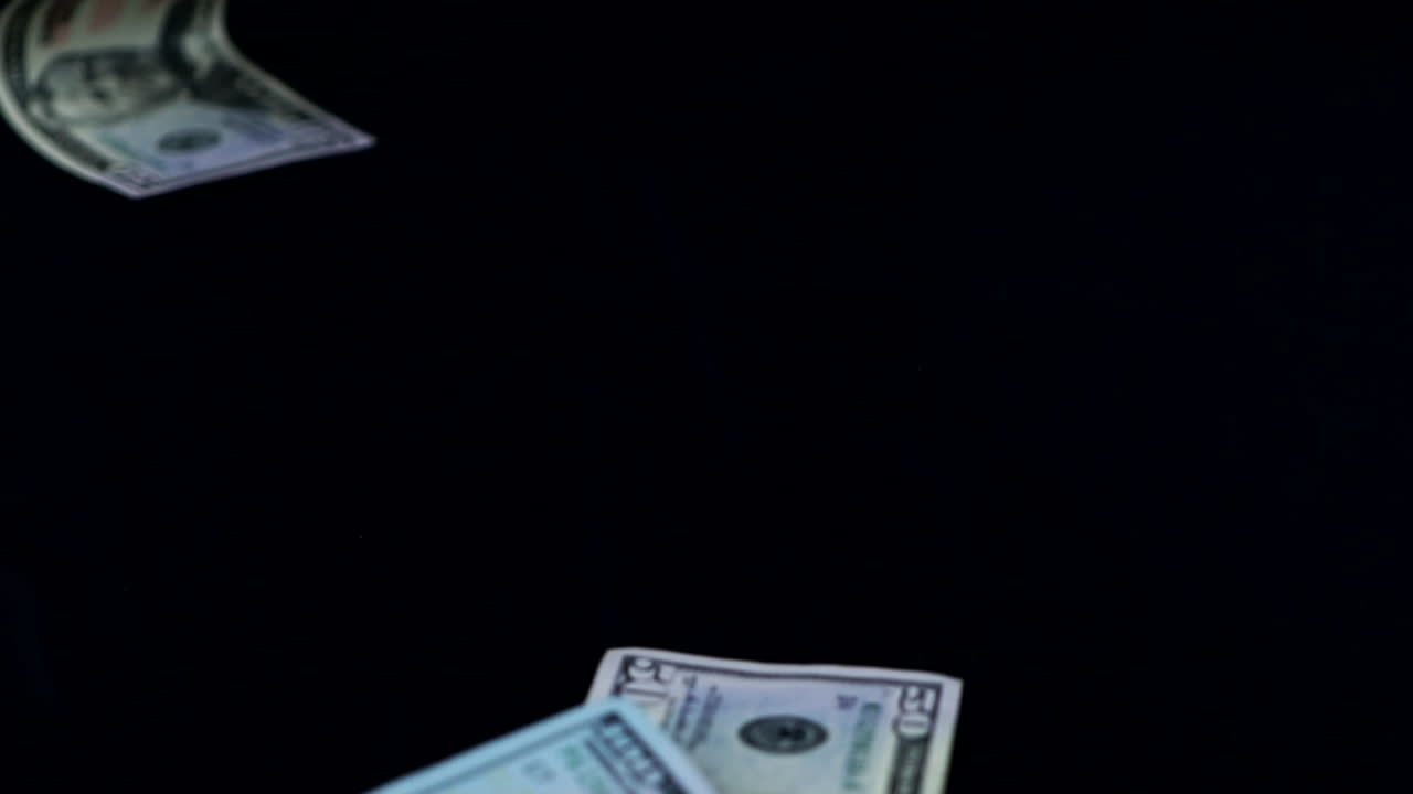USD - Banconote di dollari americani accartocciate cadute su superficie nera
