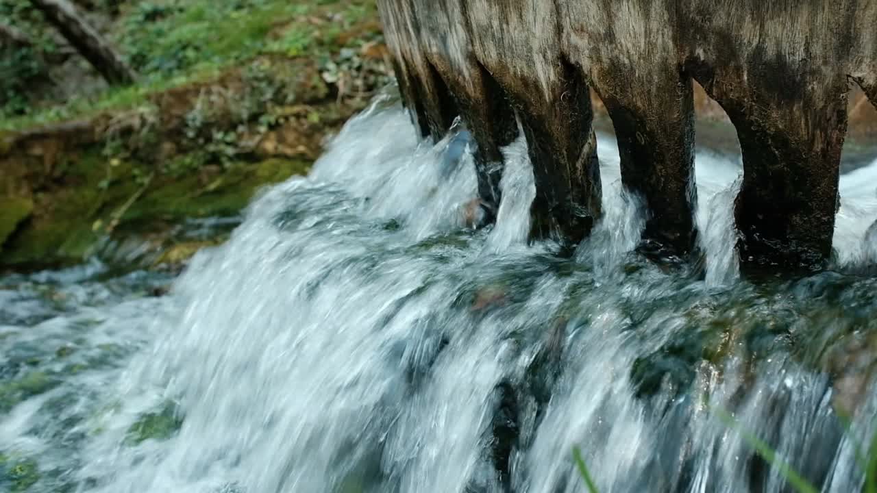 Primo piano di acqua impetuosa attraverso una paratoia di legno