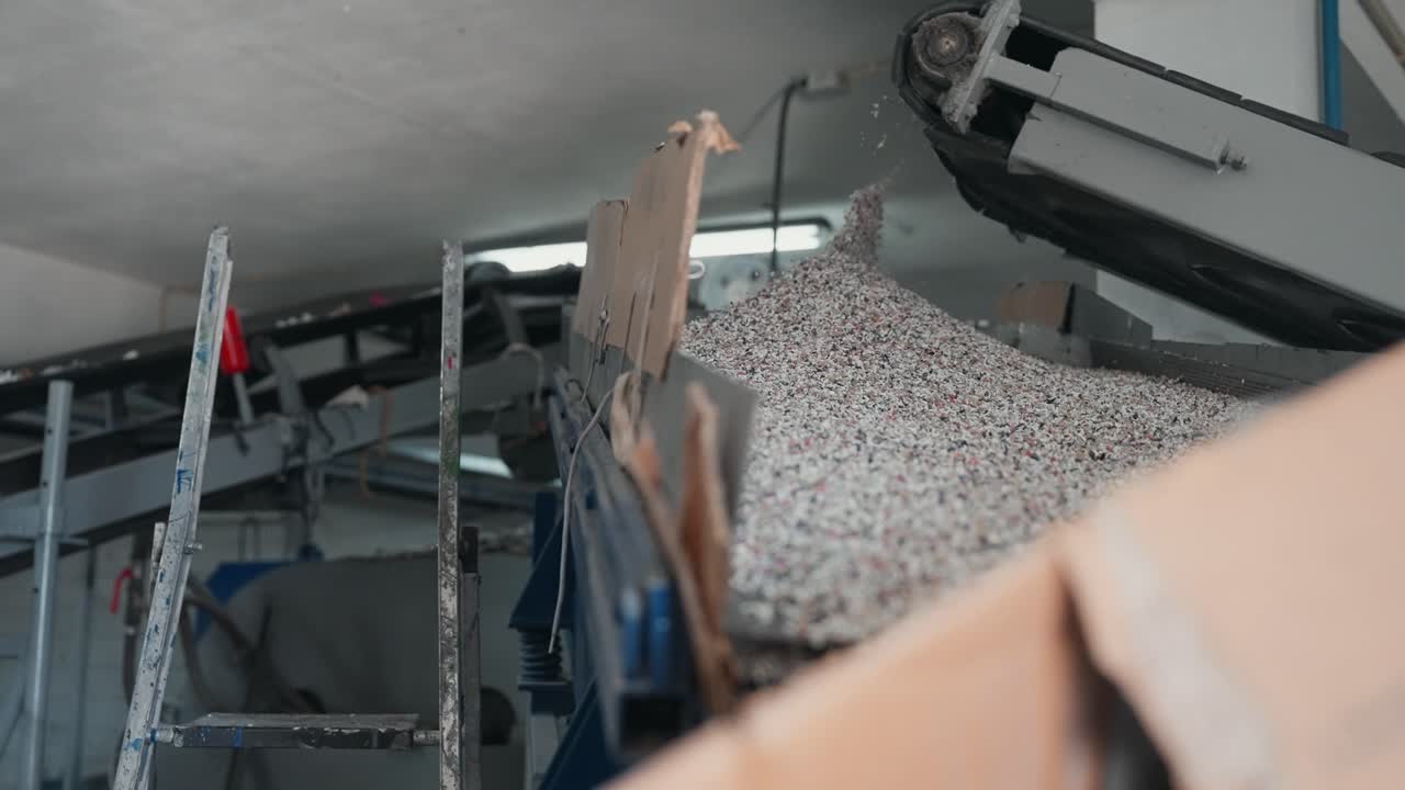 공장 컨베이어에서 수집 장소로 떨어지는 미세한 재활용 알갱이