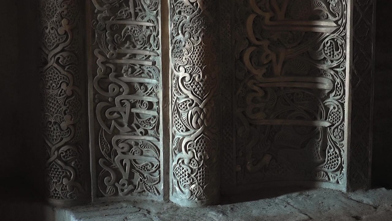 Intricate Stone Carving with Arabic Calligraphy on Ancient Architectural Wall