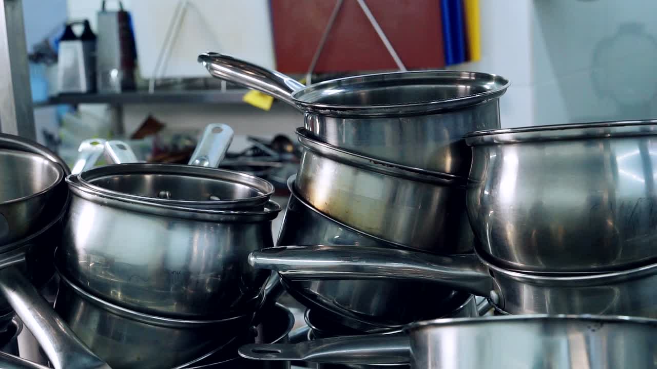 Sets of different sized cooking pots in restaurant. Kitchenware for cooking. Metal utensils stocked in the kitchen. Close-up