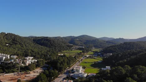 drone se mueve hacia adelante en ibiza por un camino que conduce a una pequeña playa por la bahía