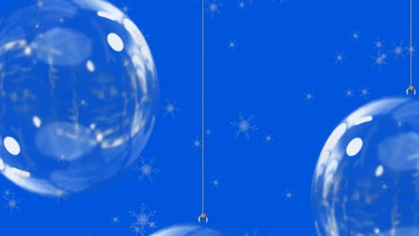 animation of snow falling over christmas bauble decorations on blue background