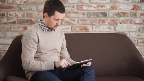 Man using a tablet on a couch