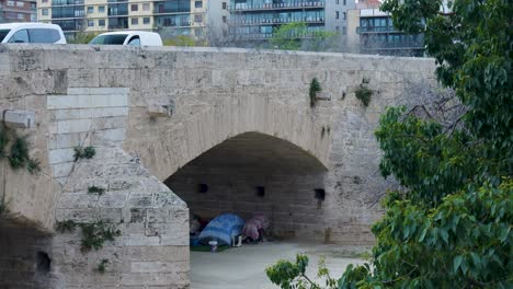 homeless people sheltering under a bridge in the city