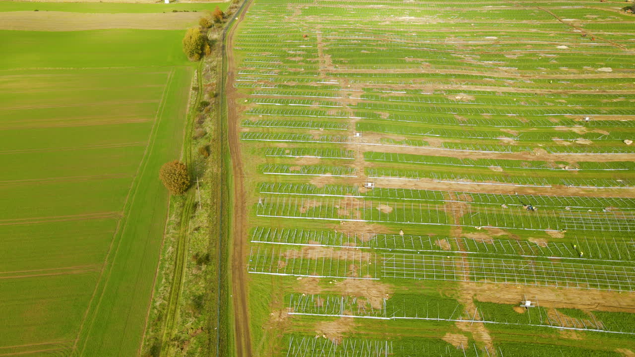 sitio de construcción de granjas fotovoltaicas de izquierda a derecha, campo verde preparado para la construcción de plantas de energía solar - antena de arriba hacia abajo
