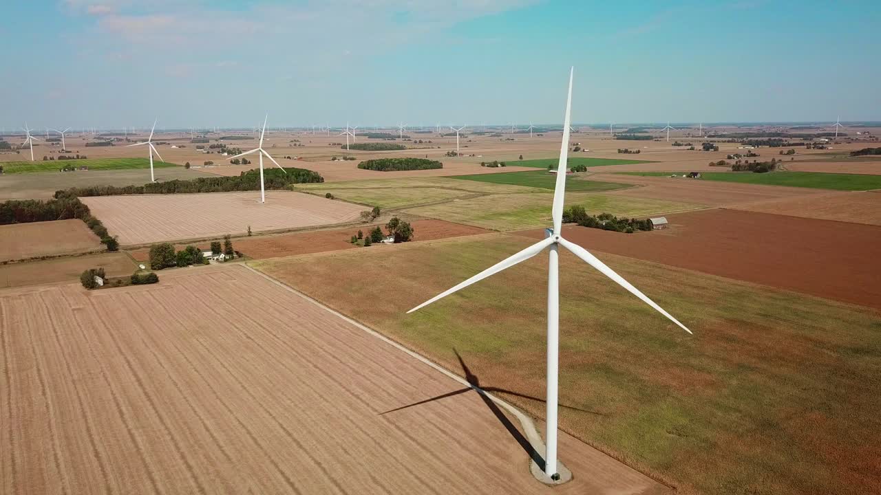 Aerial through a wind turbine producing alternative electricity in rural Michigan