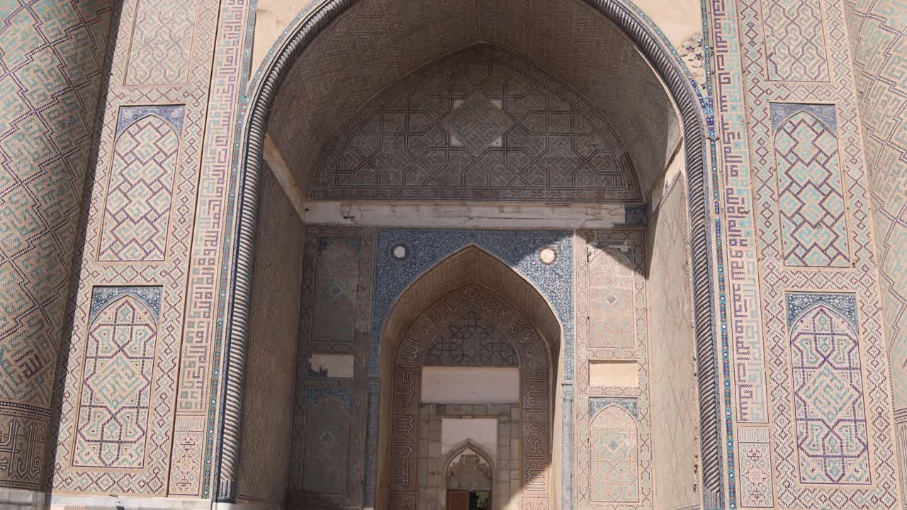 sombras contrastantes en el arco detallado de la madrasa islámica en la plaza registan en samarcanda, uzbekistán a lo largo de la histórica ruta de la seda