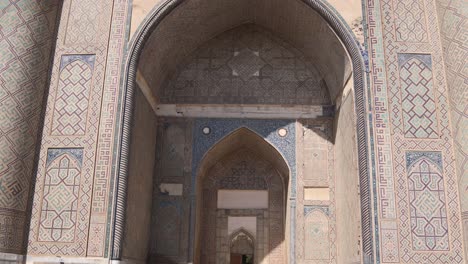 contrasting shadows on detailed archway of islamic madrassa in registan square in samarkand, uzbekistan along the historic silk road