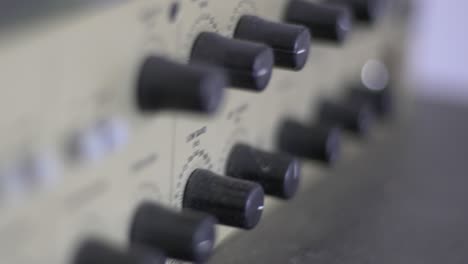 close up of knobs and switches on a audio recording device