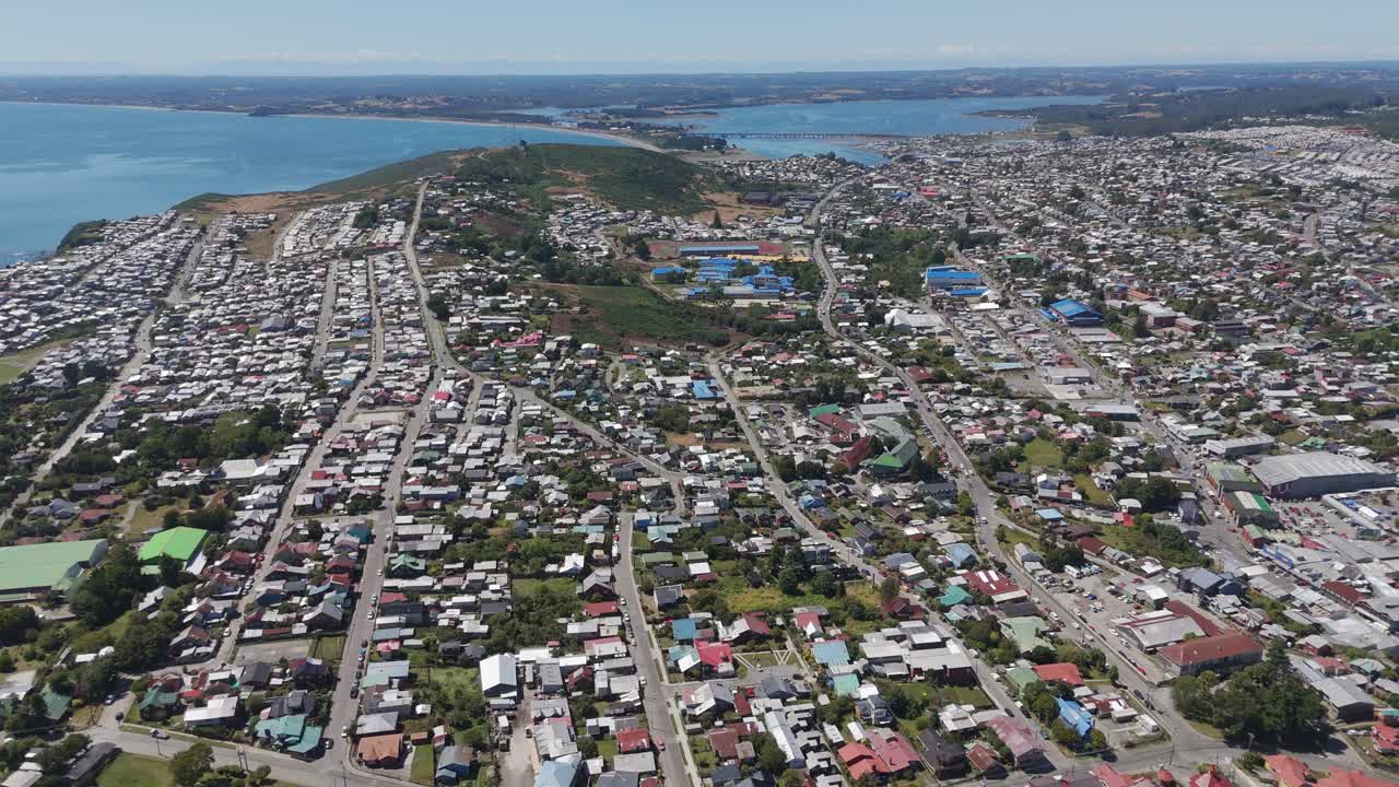 Panoramic aerial view of Ancud city on Chiloé Island showcasing its urban and coastal areas. dolly back