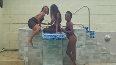 a sunny day at the pool with young girls in bikinis having fun