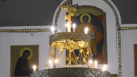 candelabro ornamentado e íconos en una iglesia