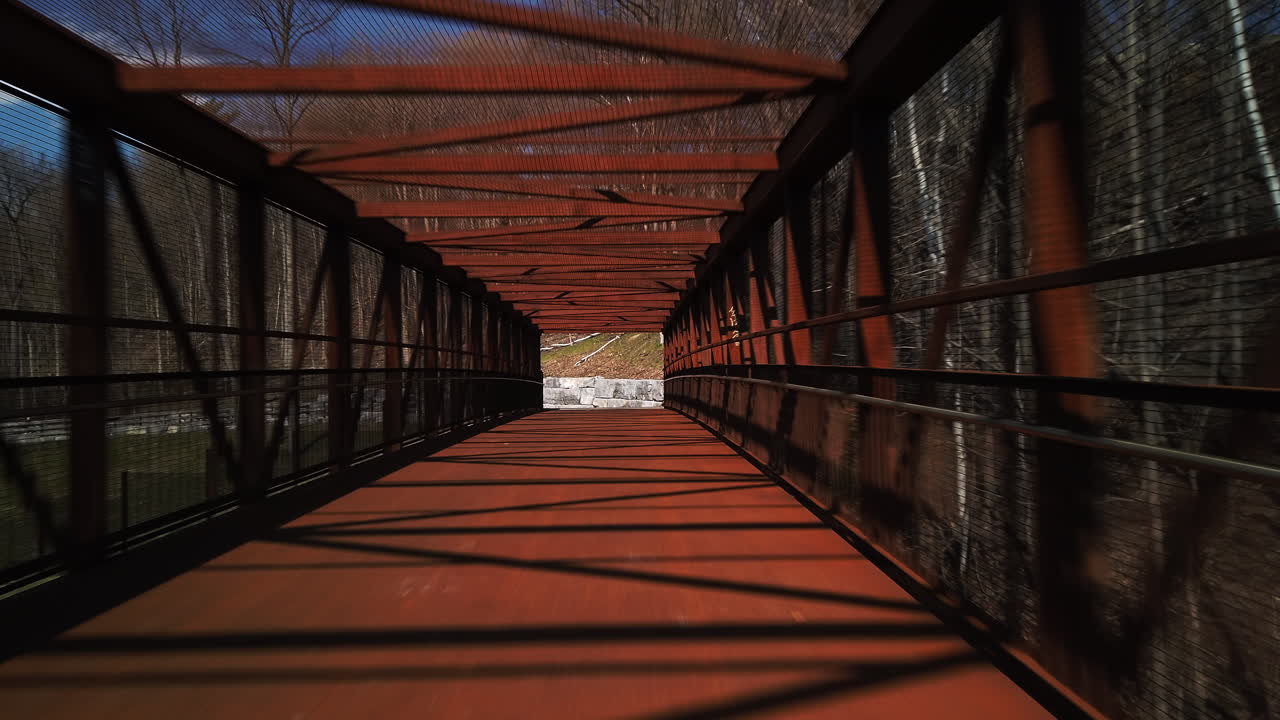 Cyclist point of view passing through a long bridge to a road on the other side, wide shot