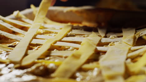 colocando tiras de masa de yema cruda encima de una lasaña, receta paso a paso