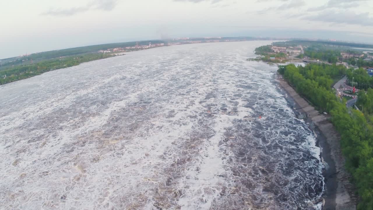 Aerial View of a River with Fast-flowing Water and a Dam