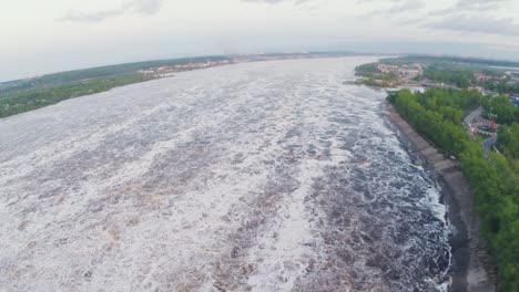 aerial view of a river with fast-flowing water and a dam